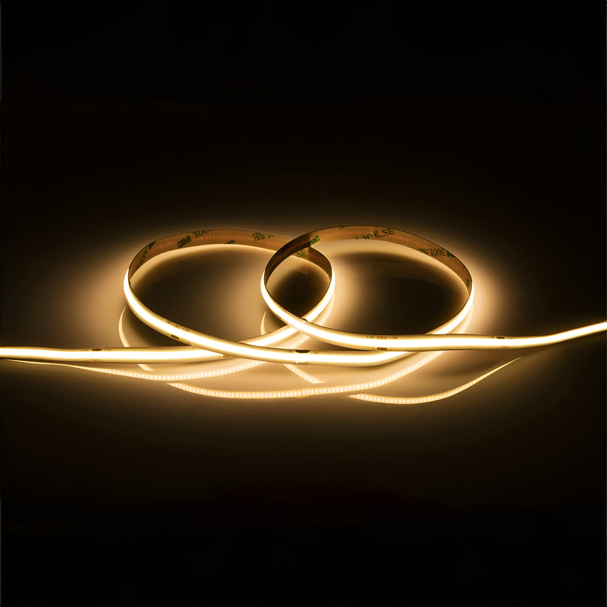 The 24V 11W COB LED Strip Light 5m - 3000K is arranged in a circular pattern against a dark background, radiating a warm yellow glow.