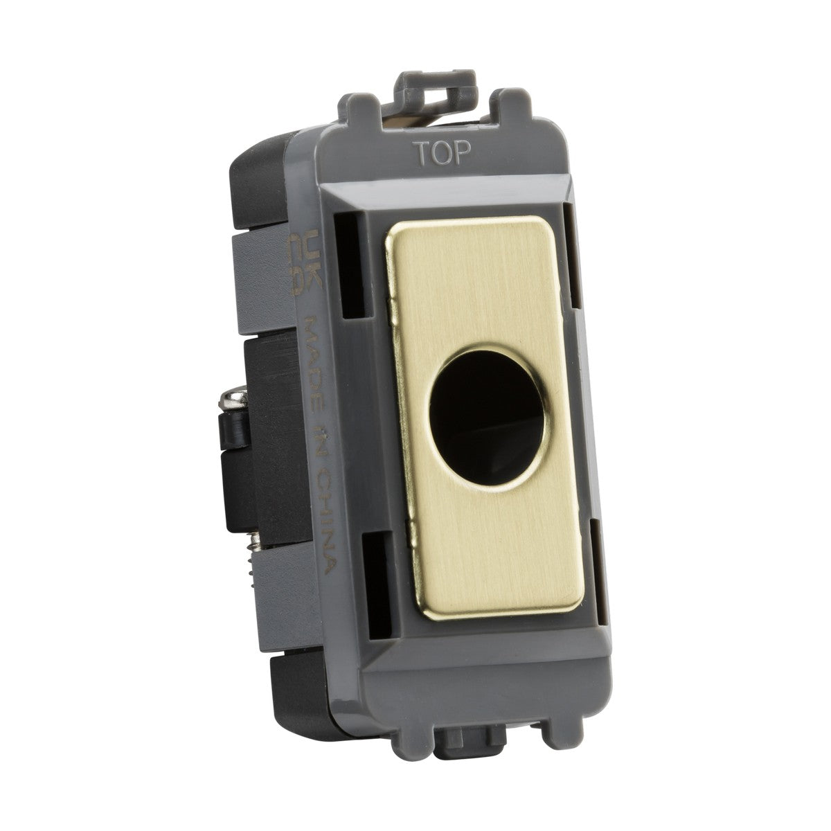 Close-up of the Flex Outlet Module's brushed brass and black electrical switch component. The front displays a circular opening. "MADE IN CHINA" is marked on the side, with "TOP" labeled on the upper edge, signifying its seamless integration within the Knightsbridge Grid system, designed with durable ABS construction.