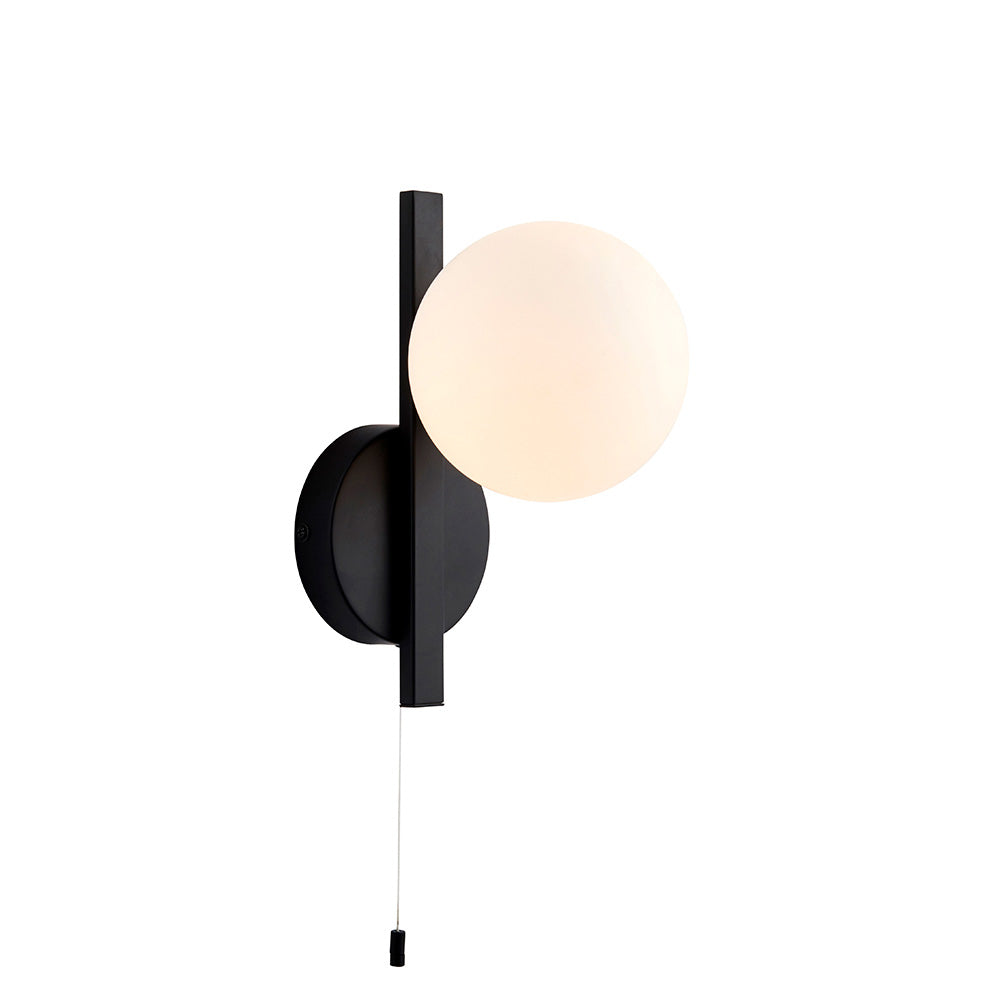 Kelham Bathroom Wall Light in black with an opal glass sphere, slim rectangular arm, round wall plate, and pull cord switch, on white background.