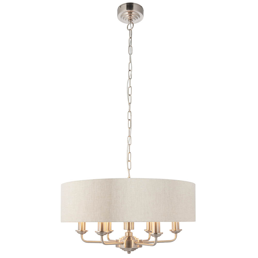 Brenley 6-light pendant with beige fabric drum shade, six chrome candle arms and E14 bulb holders, hung on a nickel chain against a plain white background.