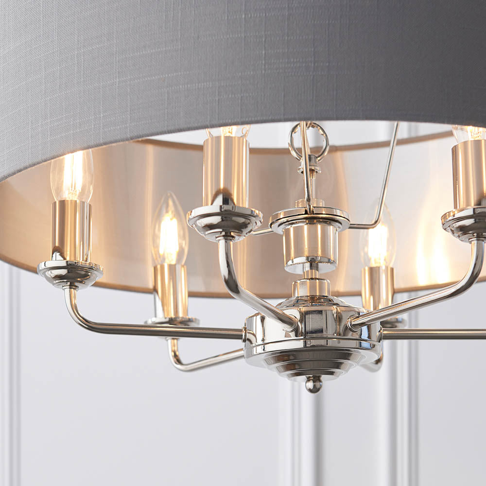 Close-up of Endon Brenley V2 6 Light Pendant in nickel and chrome, showing candle lamps beneath a grey linen shade with brushed metallic inner lining.
