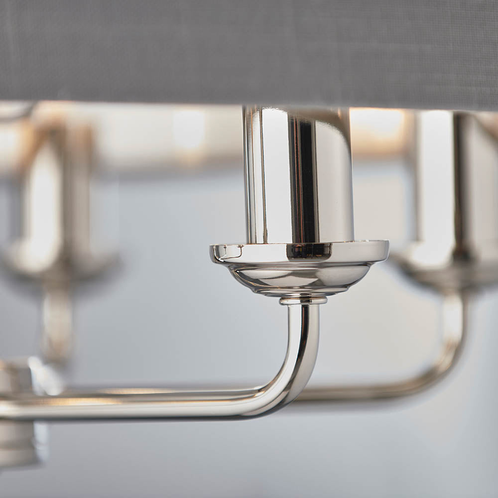Close-up of Endon Brenley V2 6 Light Pendant showing polished nickel arm, cup fitting and chrome lamp holder beneath a charcoal linen shade.