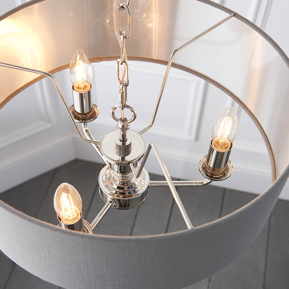 Endon Brenley V1 3 light pendant shown from below, with three E14 candle bulbs on nickel arms inside a grey linen shade with brushed metallic lining.