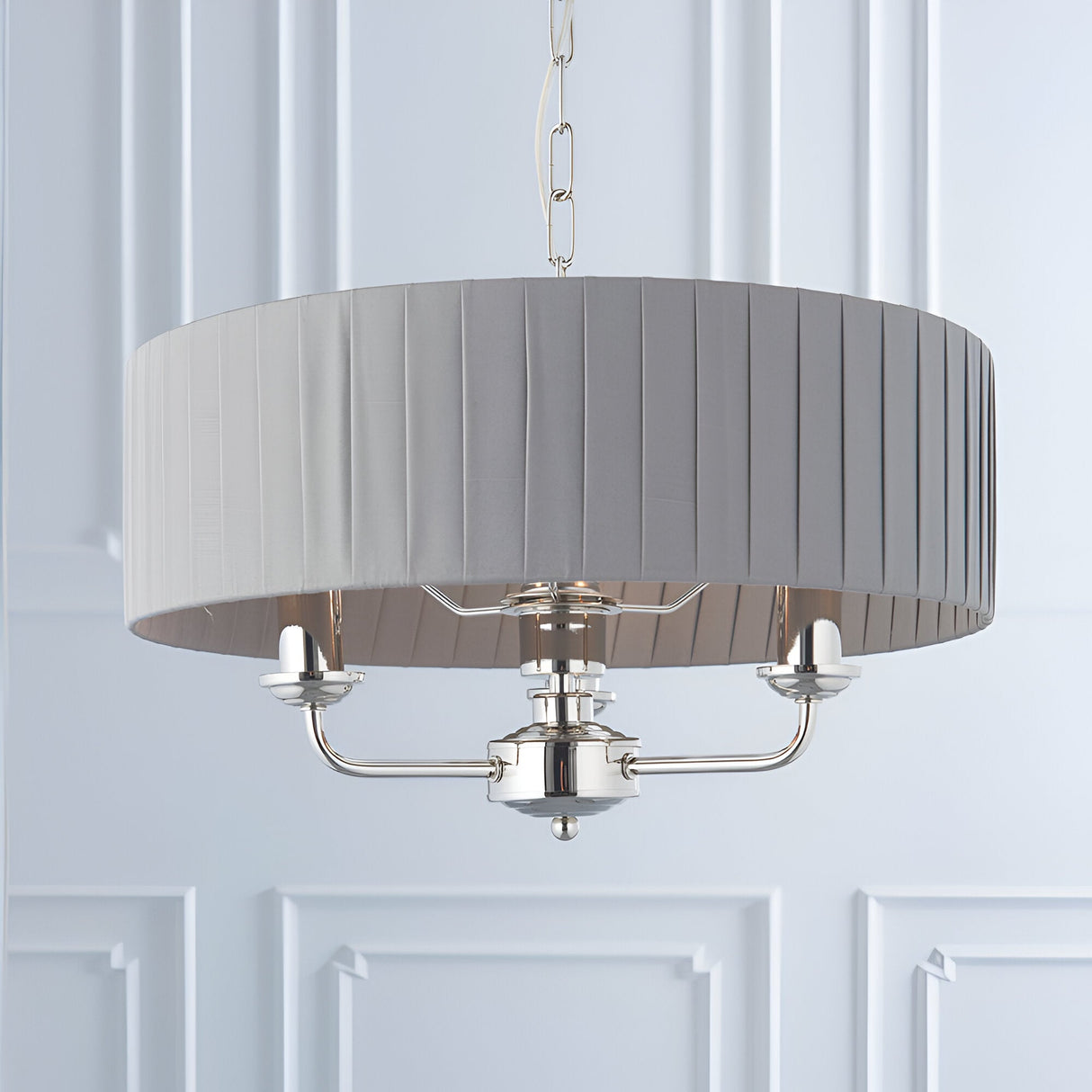 Brenley V2 3-light pendant in nickel with a grey pleated fabric drum shade, three candle-style arms, and chain suspension.