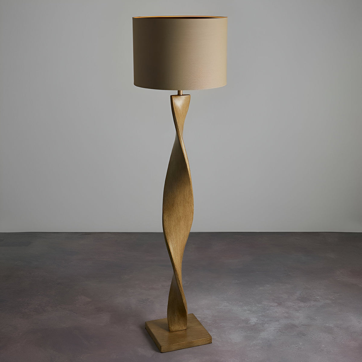 Endon Alcott floor lamp with a spiralling light oak effect base and natural linen cylinder shade, shown on a plain grey studio background.