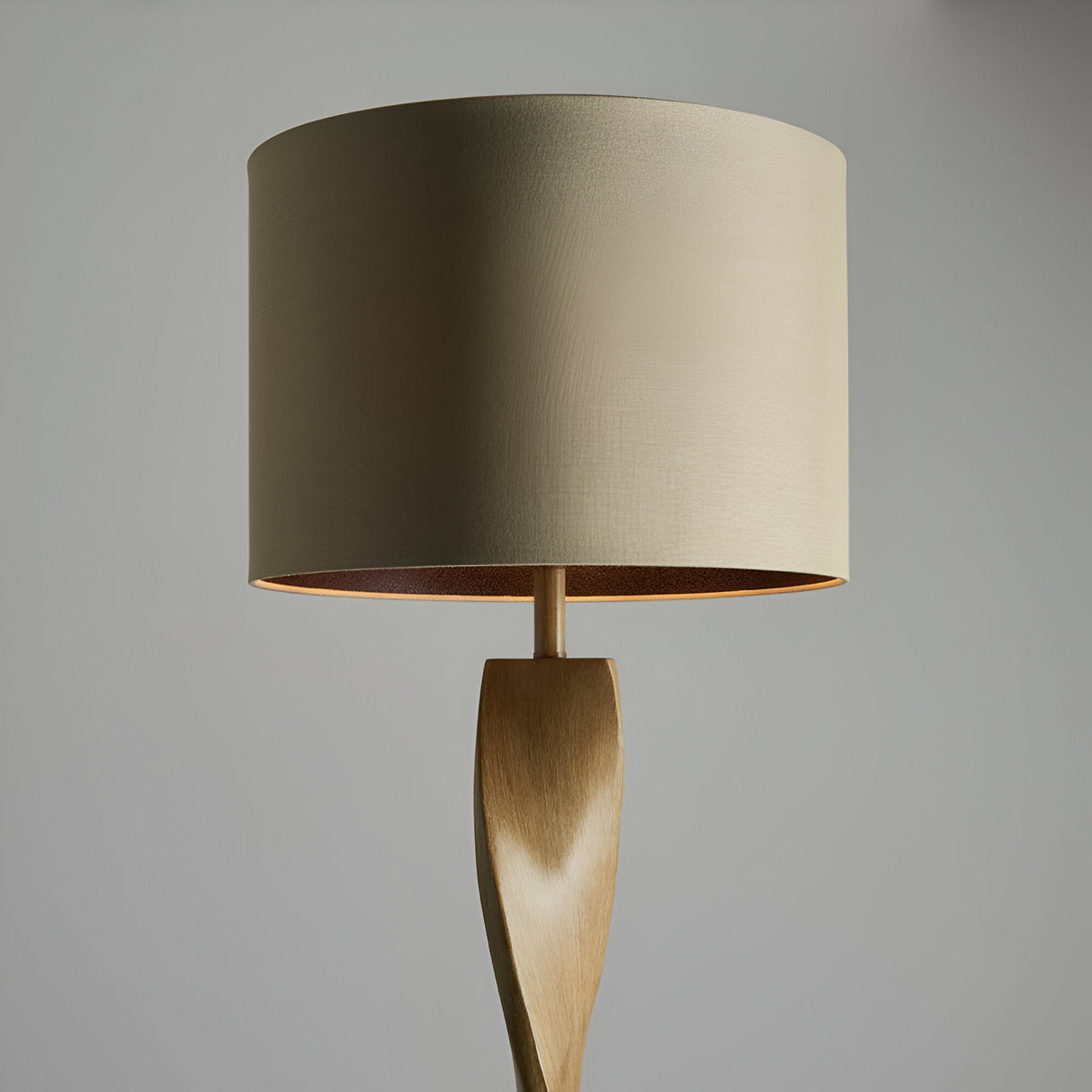 Endon Alcott floor lamp detail showing the spiralling light oak effect base topped with a natural linen cylinder shade against a grey background.