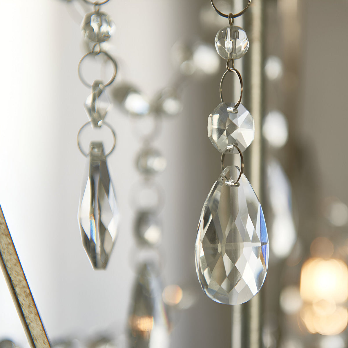 Close-up of Endon Aldwood 3 Light Pendant in silver, showing clear faceted crystal teardrop and octagonal droplets linked by beaded chains on aged metalwork.