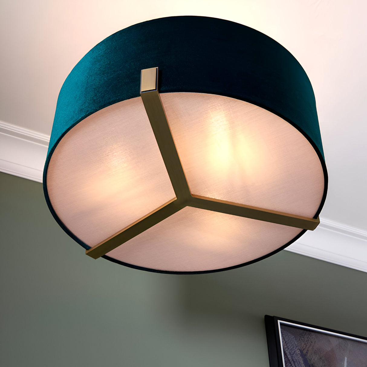 Brendon 3 Light Pendant with teal velvet drum shade, white fabric diffuser, and brass tri-arm frame, shown against a ceiling and sage green wall.