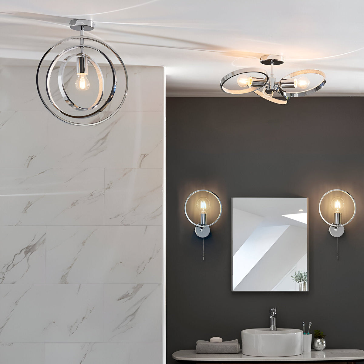 Endon Carlcombe chrome bathroom wall lights with faceted rings flank a square mirror above a basin, with matching ceiling fittings in a modern bathroom.