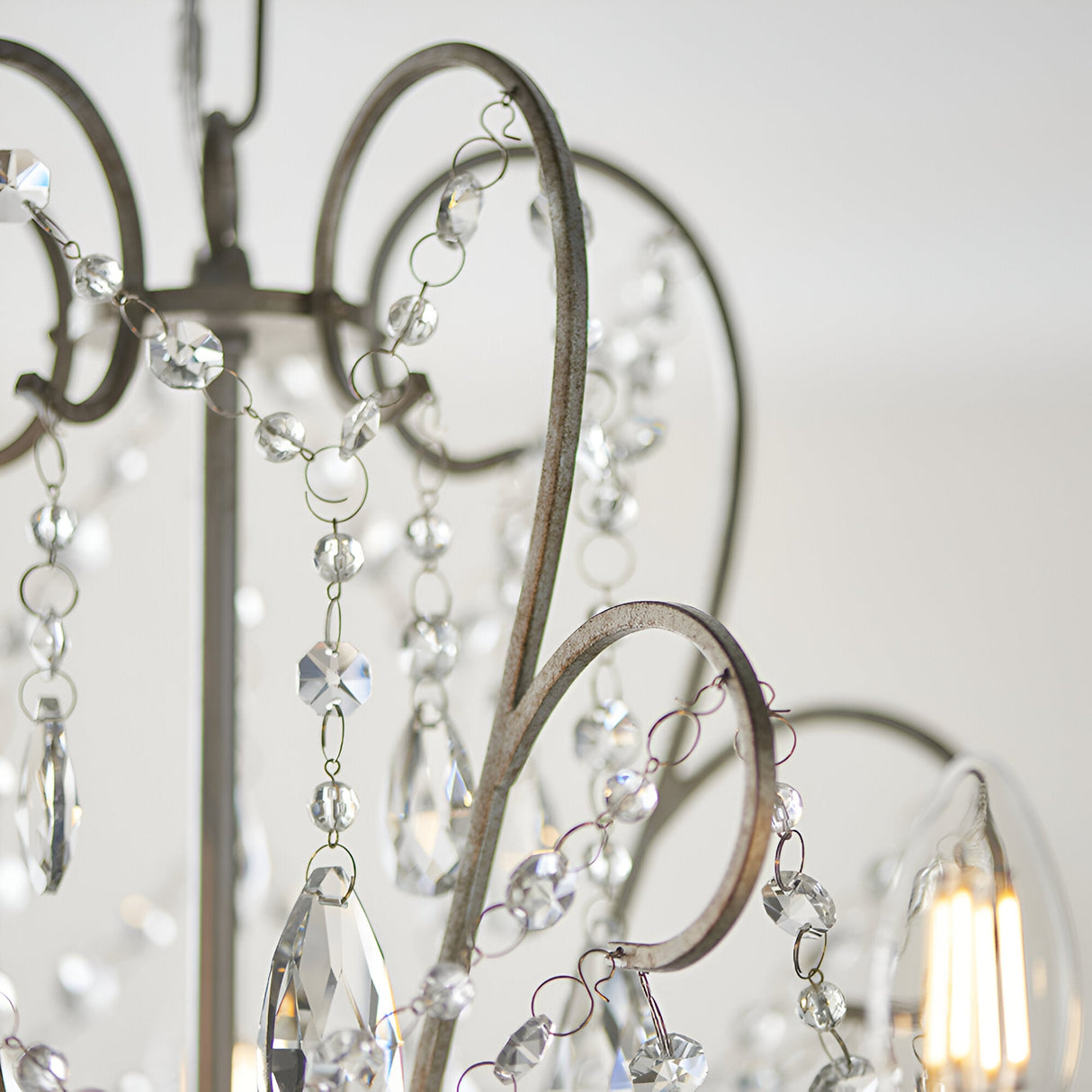 Close-up of Endon Aldwood 5 light pendant showing aged silver scrolled metalwork strung with clear faceted cut crystal beads and drops.
