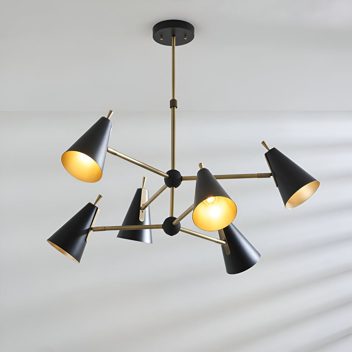 Brackwick 6 Light Pendant with matt black cone shades on brass arms and stem, adjustable angles, shown against a plain light background.