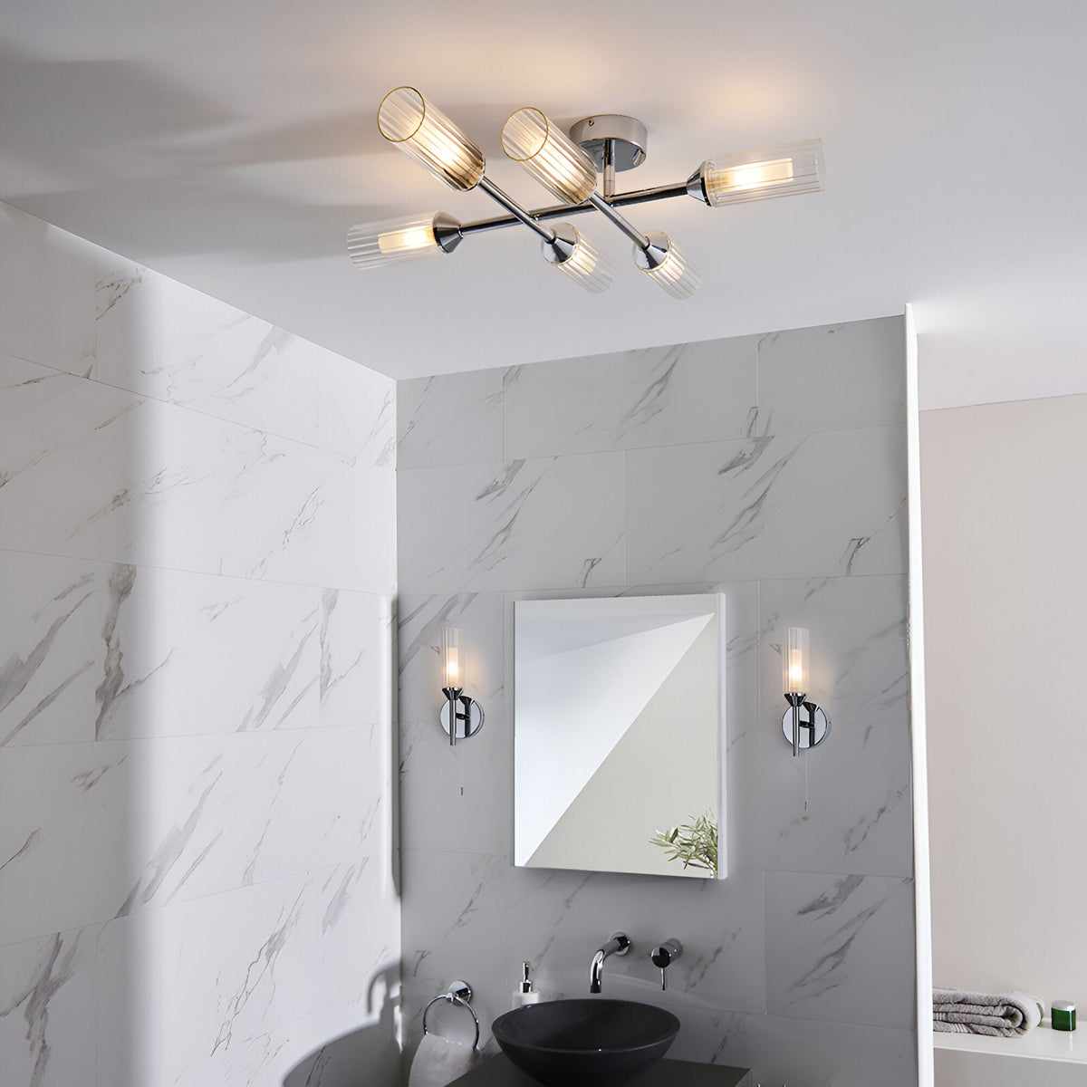 Endon Castbourne bathroom setting with a six-light chrome ceiling fitting and two matching wall lights with ribbed glass shades on marble tiles.