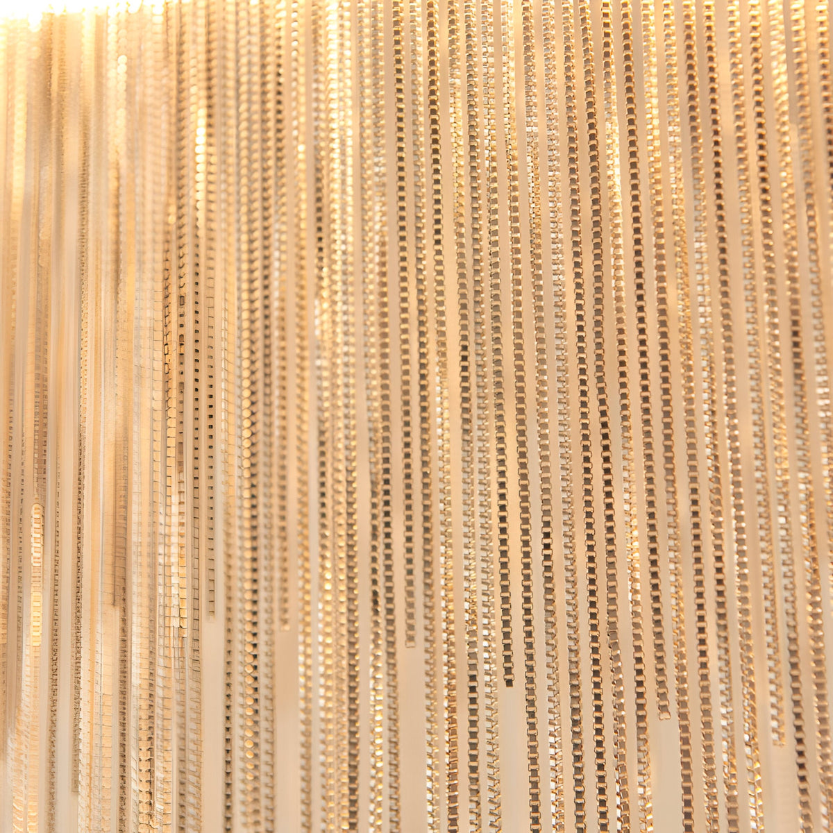 Close-up of the Endon Caststead Linear Pendant showing cascading fine silver chains in a polished chrome finish catching warm light.