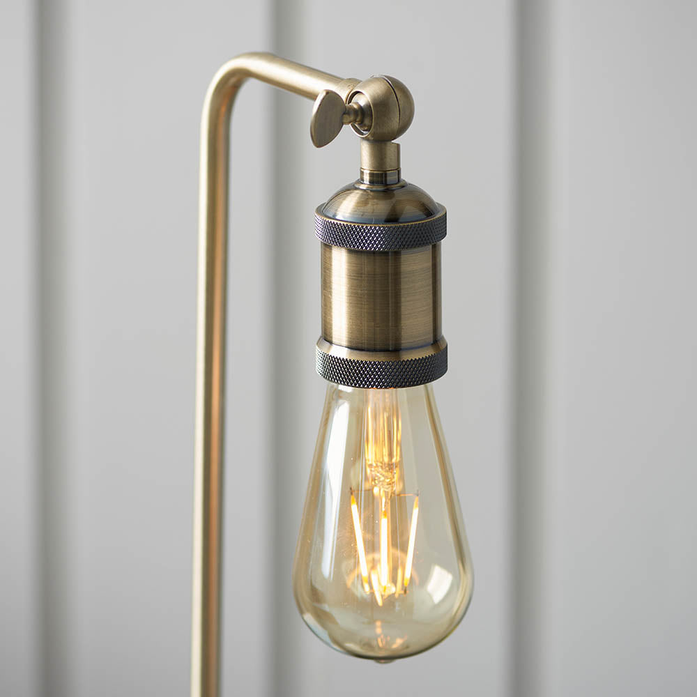 Close-up of the Brackley Table Lamp in brass, showing an adjustable knuckle joint, knurled lamp holder and exposed E27 bulb against a light background.