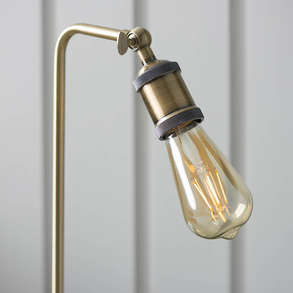 Brackley Table Lamp in brass showing an adjustable knuckle joint, knurled E27 bulb holder, and exposed filament bulb against a light background.