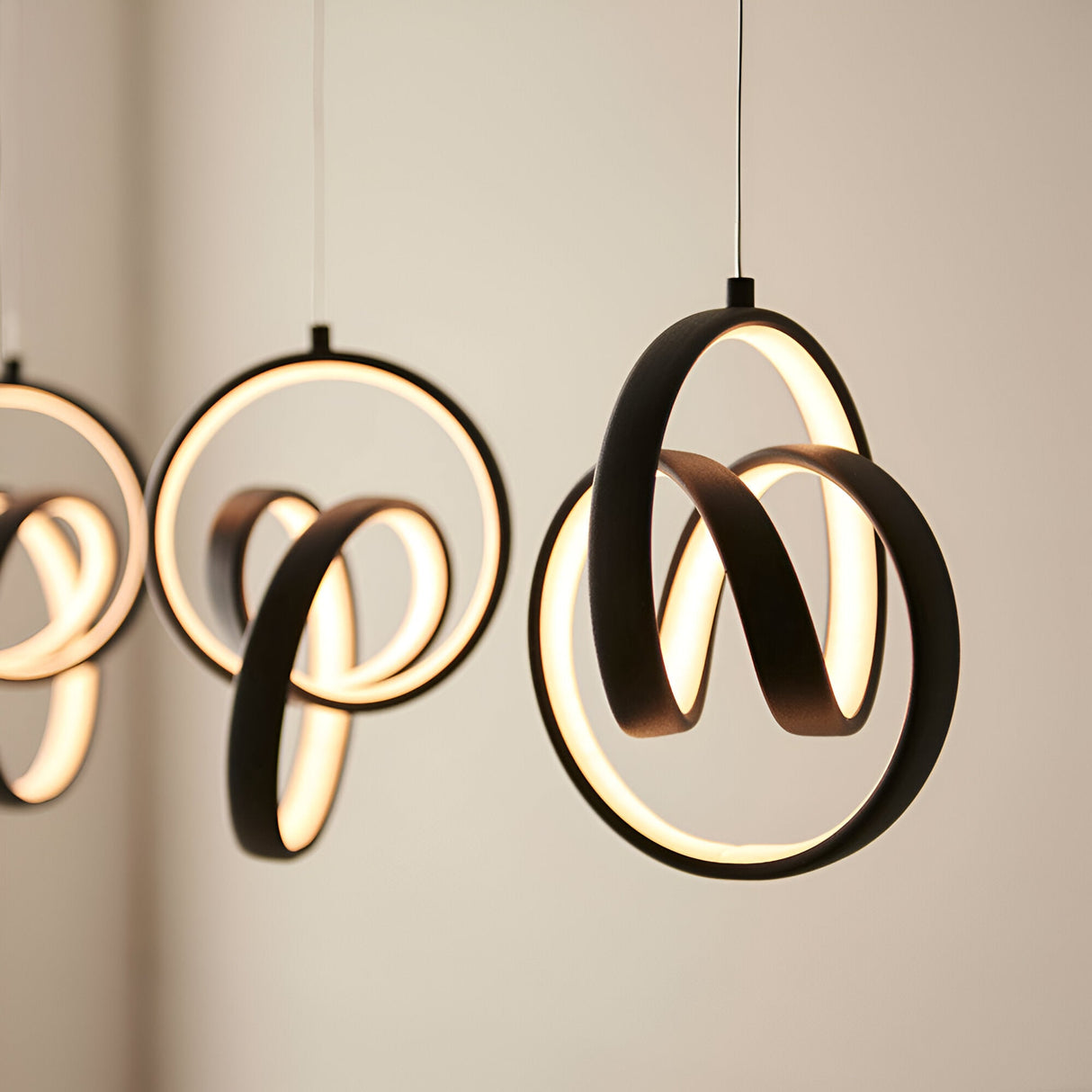 Bevwell 5 Light Linear Pendant in matt black metal, looped ring forms with integrated LED lighting, shown against a plain neutral wall.