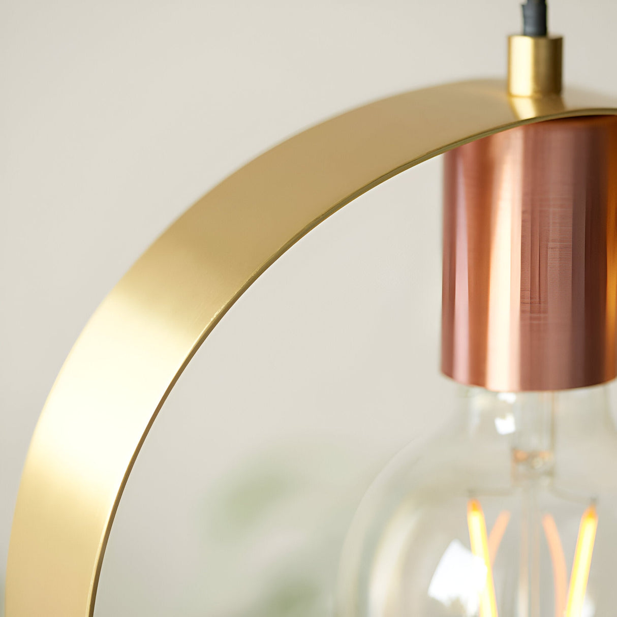 Close-up of the Brenmere Pendant Light showing the brushed brass open hoop frame and copper lamp holder with visible E27 filament bulb.