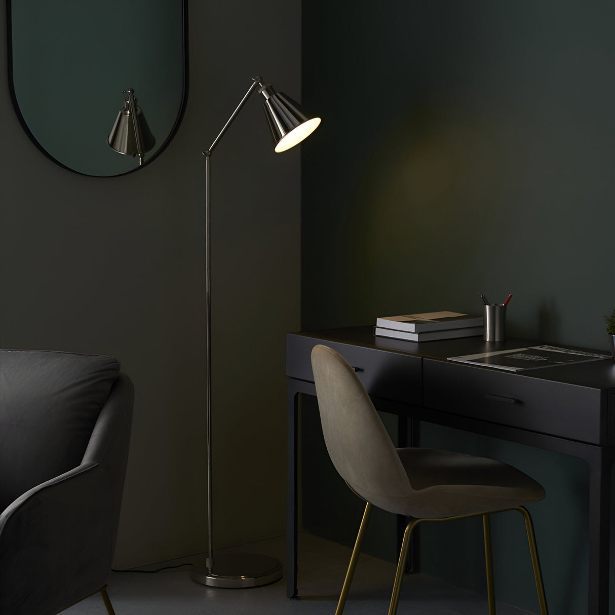 Endon Brackley nickel floor lamp with adjustable arm and cone shade, lit beside a dark desk and chair in a green-walled room with oval mirror.