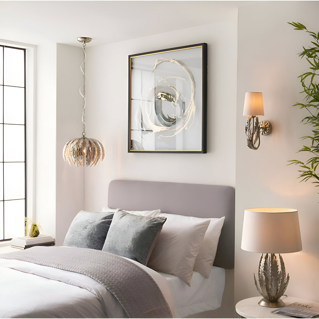 Endon Colette table lamp with layered silver leaf metal base and ivory cotton shade on a bedside table in a neutral bedroom setting.