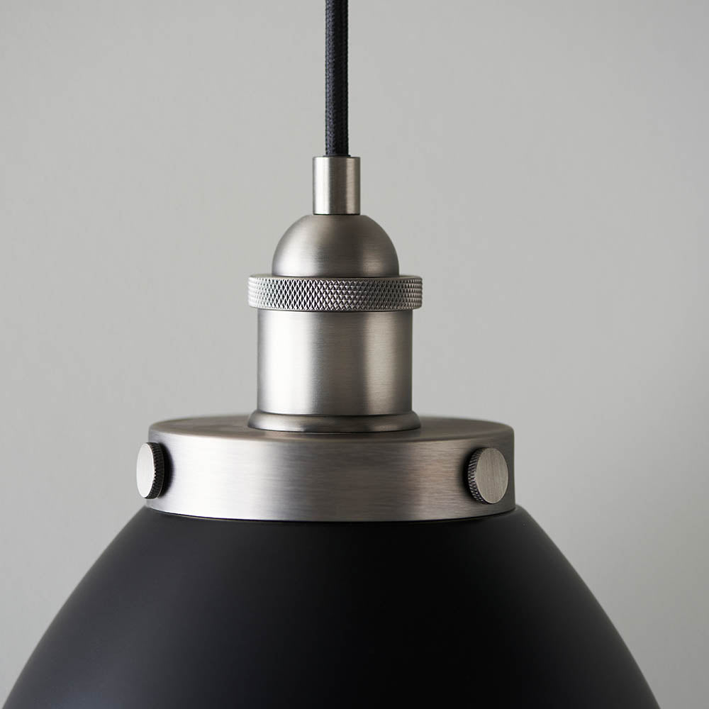 Close-up of the Endon Bramdale Small Pendant showing aged pewter lamp holder and knurled ring above matt black rolled-edge shade on light grey background.