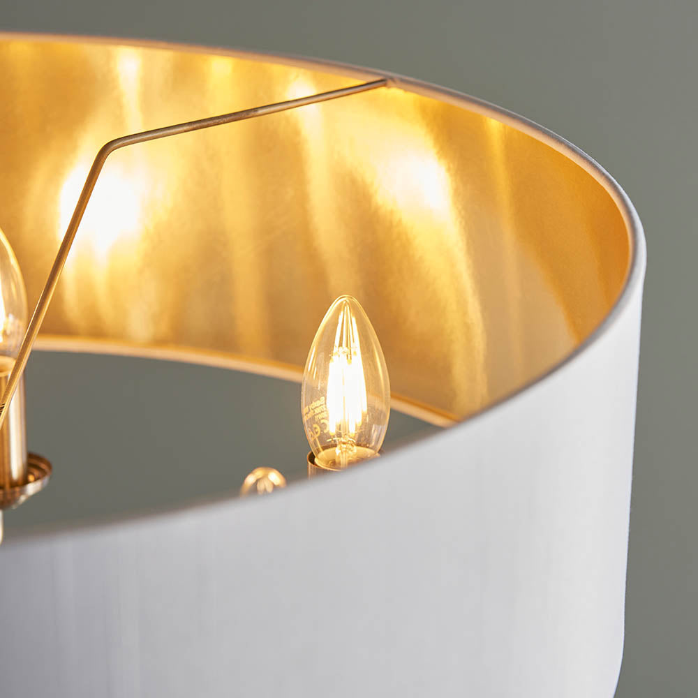 Close-up of Endon Brenley V1 6 Light Pendant showing a white fabric shade with gold-lined interior and lit E14 candle bulbs on chrome arms.