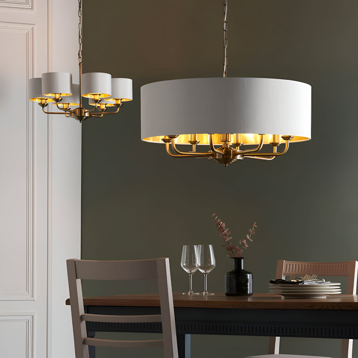 Endon Brenley 8 light pendant in brass with white drum shade and gold-lined interior, shown beside a smaller matching chandelier above a dining table.