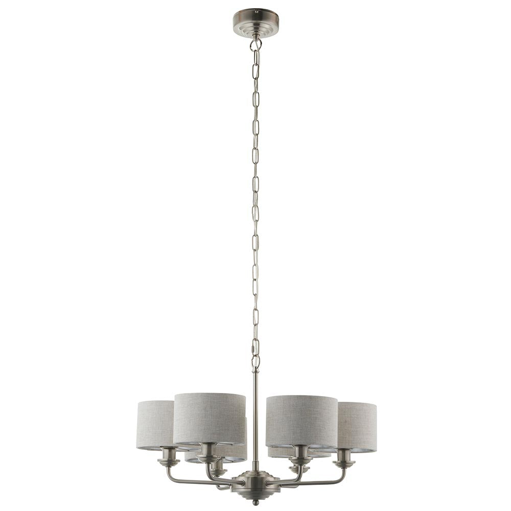 Brenley 6-light pendant in brushed chrome with six curved arms and grey linen drum shades, hung from a long chain on a plain white background.