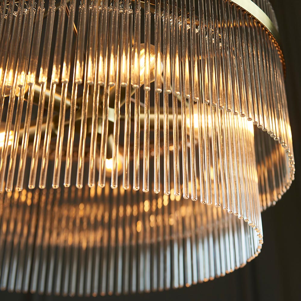 Close-up of the Endon Beaumont 5 Light Pendant in brass, showing tiered clear glass rods around illuminated E14 lamps.