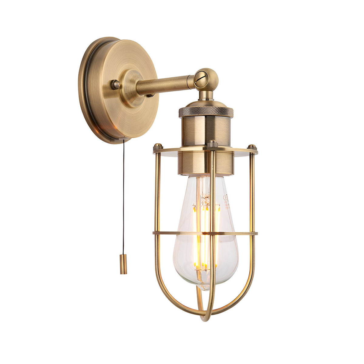 Bevwood industrial brass wall light with round backplate, pull cord switch, and open cage shade around an exposed E27 filament bulb.