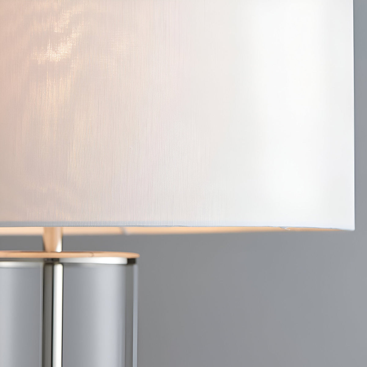 Close-up of the Endon Caldley table lamp showing the vintage white fabric drum shade and clear cylindrical glass base with nickel fitting.
