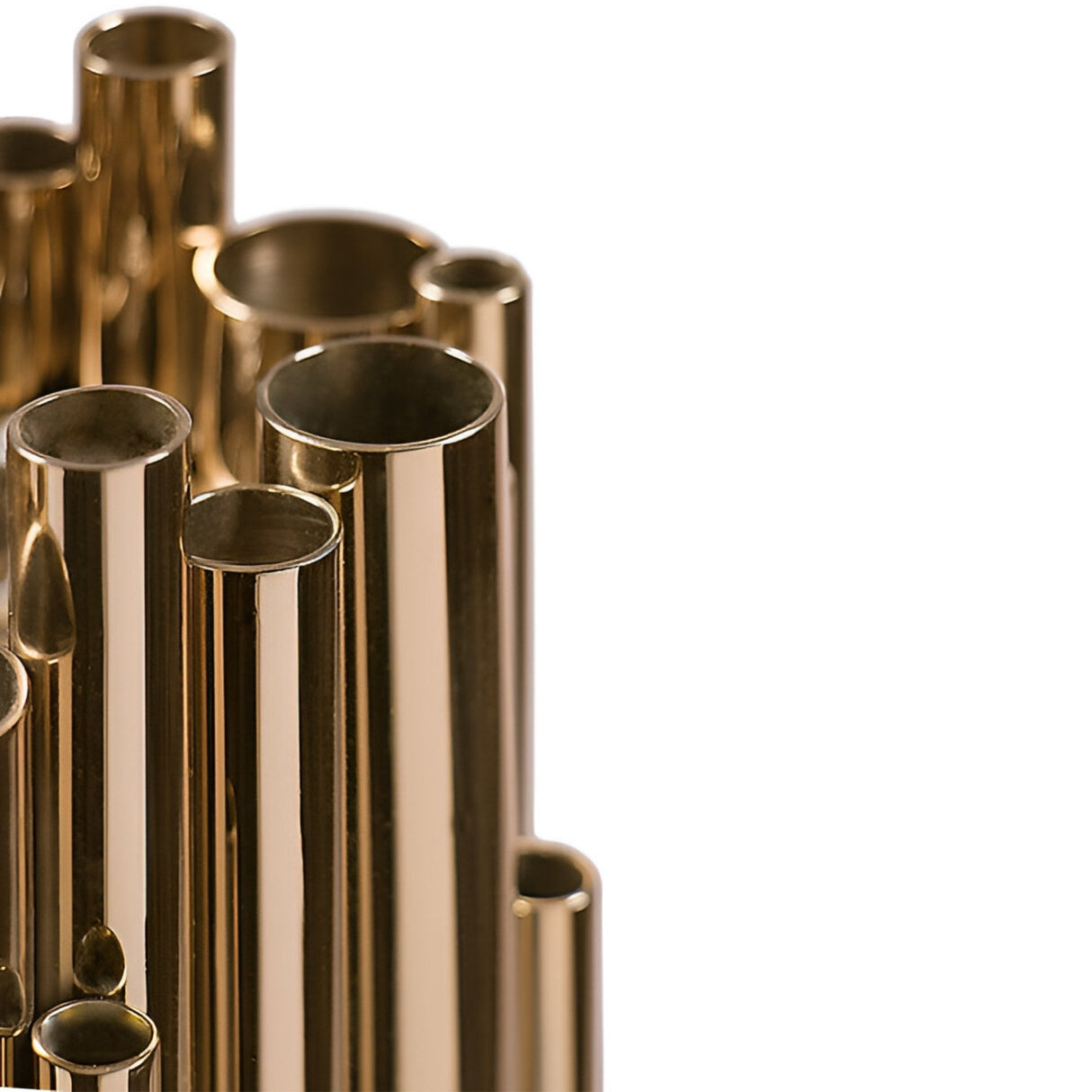 Close-up of shiny, gold-colored metal tubes of varying heights arranged together, resembling the pipes of the Aurelio 6 Light Brass Pendant - Gold, against a white background.