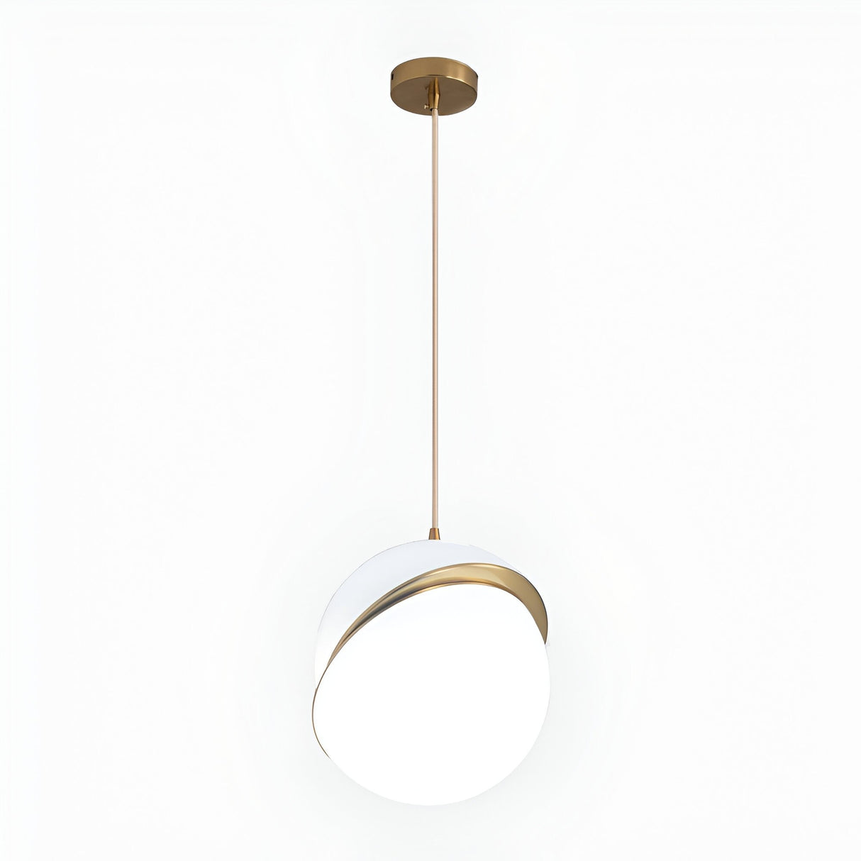 The Arc Pendant Light - Gold & White features a round white globe shade with a brushed brass accent band, hung from the ceiling by a slim gold rod and circular gold mount, emphasizing its modern look.