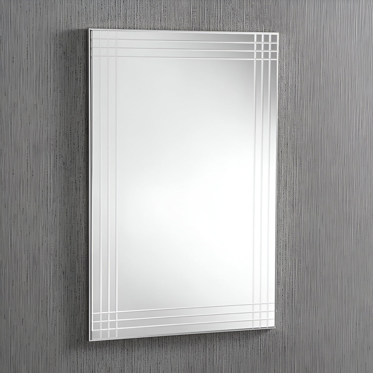 The Glare Crystal Rectangle Wall Mirror - 92x62cm, with its decorative etched border featuring parallel lines in the corners, is mounted on a textured gray wall. Reflecting subtle light, it epitomizes modern elegance and transforms any space into a luxury home decor masterpiece.