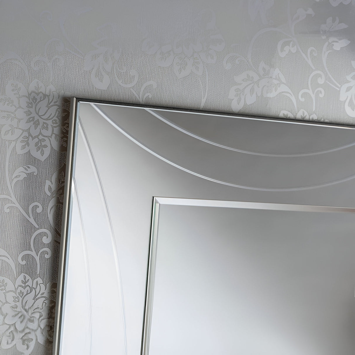 A detailed view of the Lumis Rectangle Wall Mirror Silver - 108x77cm, showcasing its stylish silver frame that exudes modern elegance as it reflects a subtly patterned wall with a floral motif.