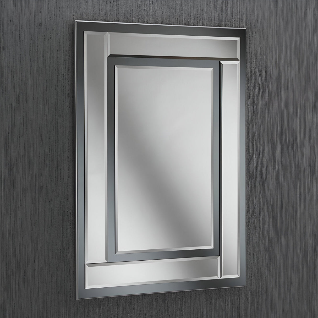 A Glassis Rectangle Wall Mirror - 112x81cm with a decorative geometric border hangs on a textured, dark gray wall. This mirror's minimalist design features overlapping rectangles, adding depth and visual interest, making it an ideal choice for modern interiors.
