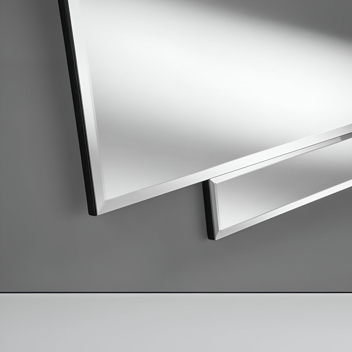 Close-up of a modern flat-screen TV mounted on a gray wall, situated next to the Imperia Panel Wall Mirror - 122x51cm. The image emphasizes the sleek edges and thin bezel of the television, which integrates seamlessly with the mirror to create a harmonious architectural element in minimalist home decor.