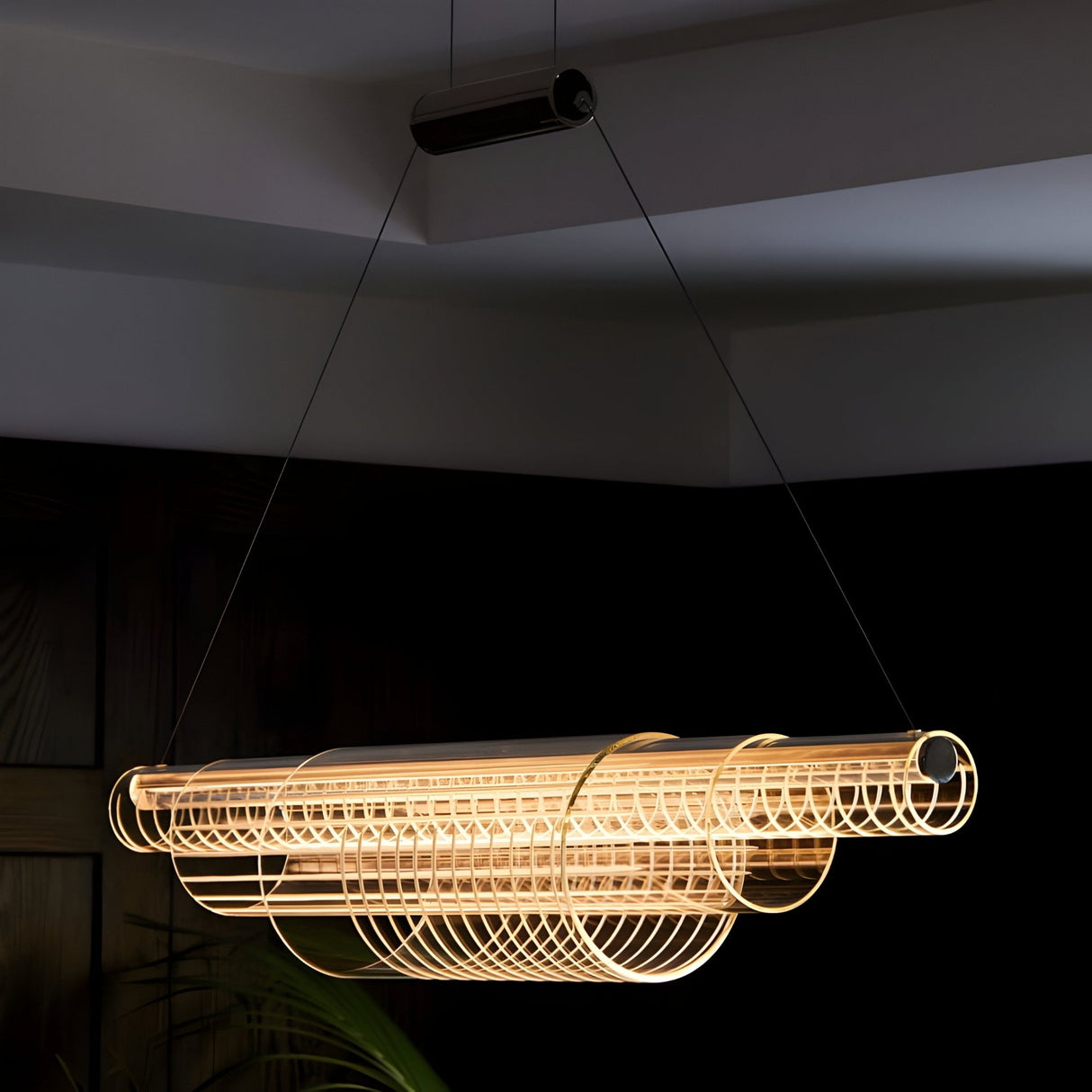 The Celestri LED Linear Suspension Light in silver features a modern cylindrical design with concentric wire loops, suspended by two cables and casting a warm glow—ideal for contemporary interiors.