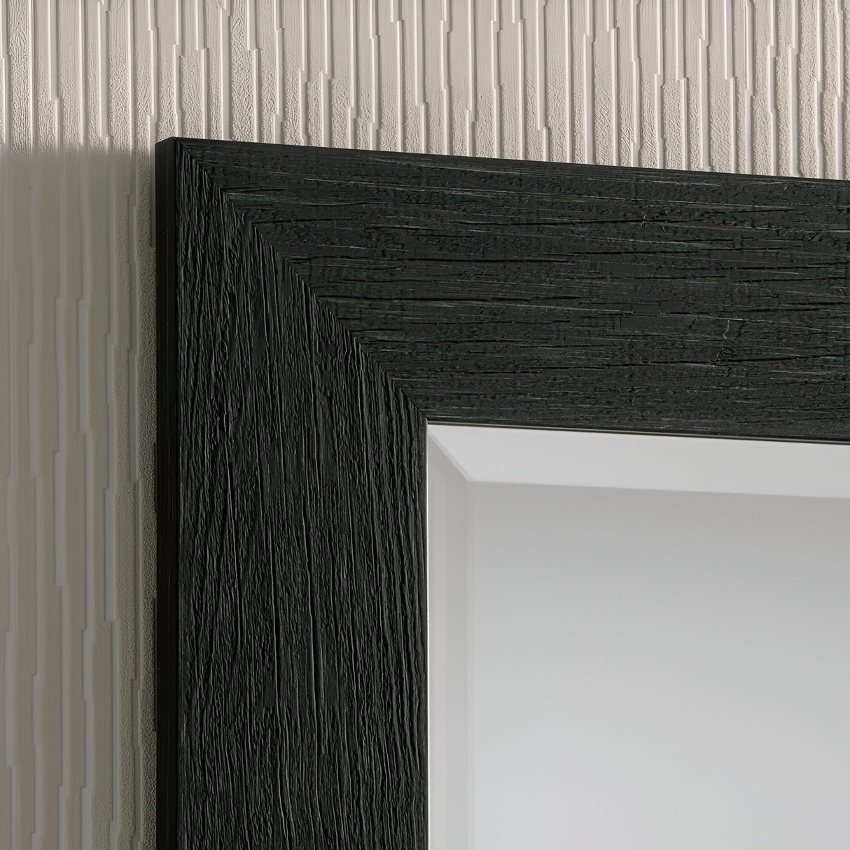 Close-up of a black frame corner featuring a textured border. It complements the Zennia Rectangle Wall Mirror - Black, showcased against linear embossed wallpaper, establishing an elegant contrast between the minimalist interiors and the richly textured background.