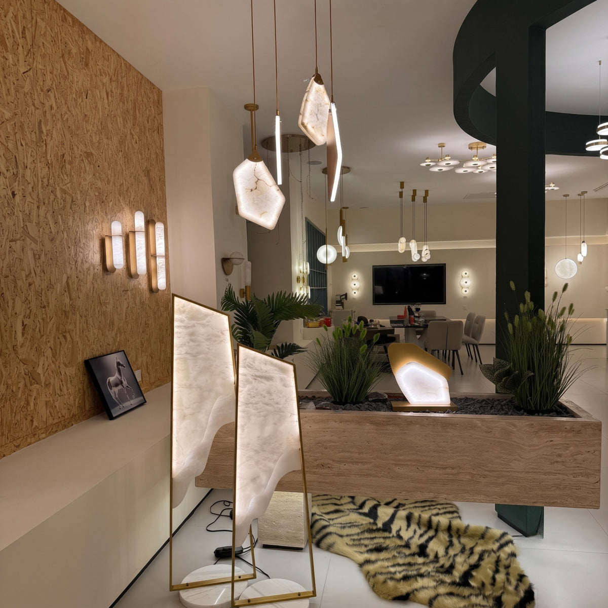 Atria LED Large Alabaster Floor Lamp with brushed brass frame and circular marble base, shown illuminated in a showroom setting.