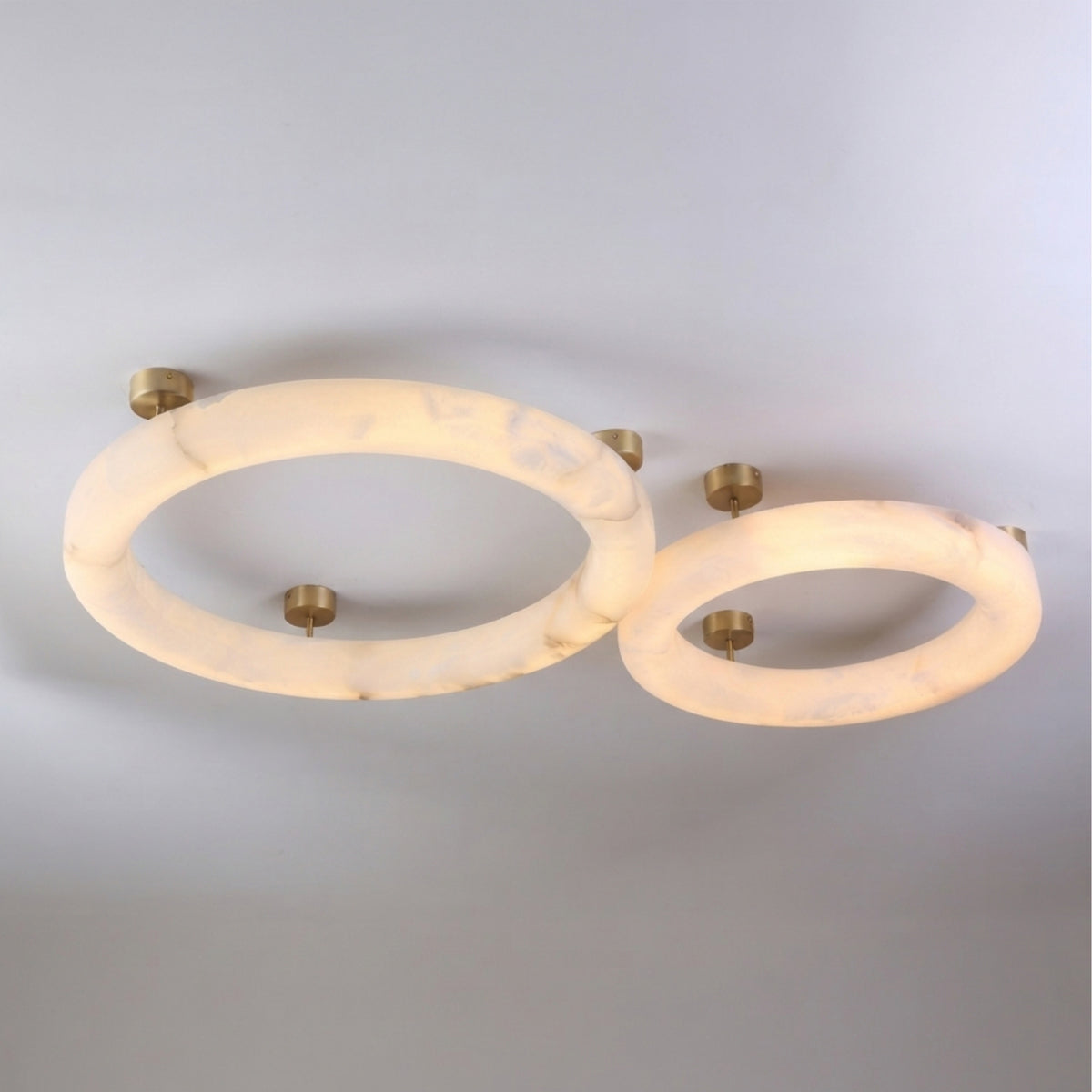 Orbis Extra Large LED Alabaster Semi-Flush Ceiling Light in soft white, showing two overlapping alabaster rings with brushed brass ceiling mounts on a plain light background.