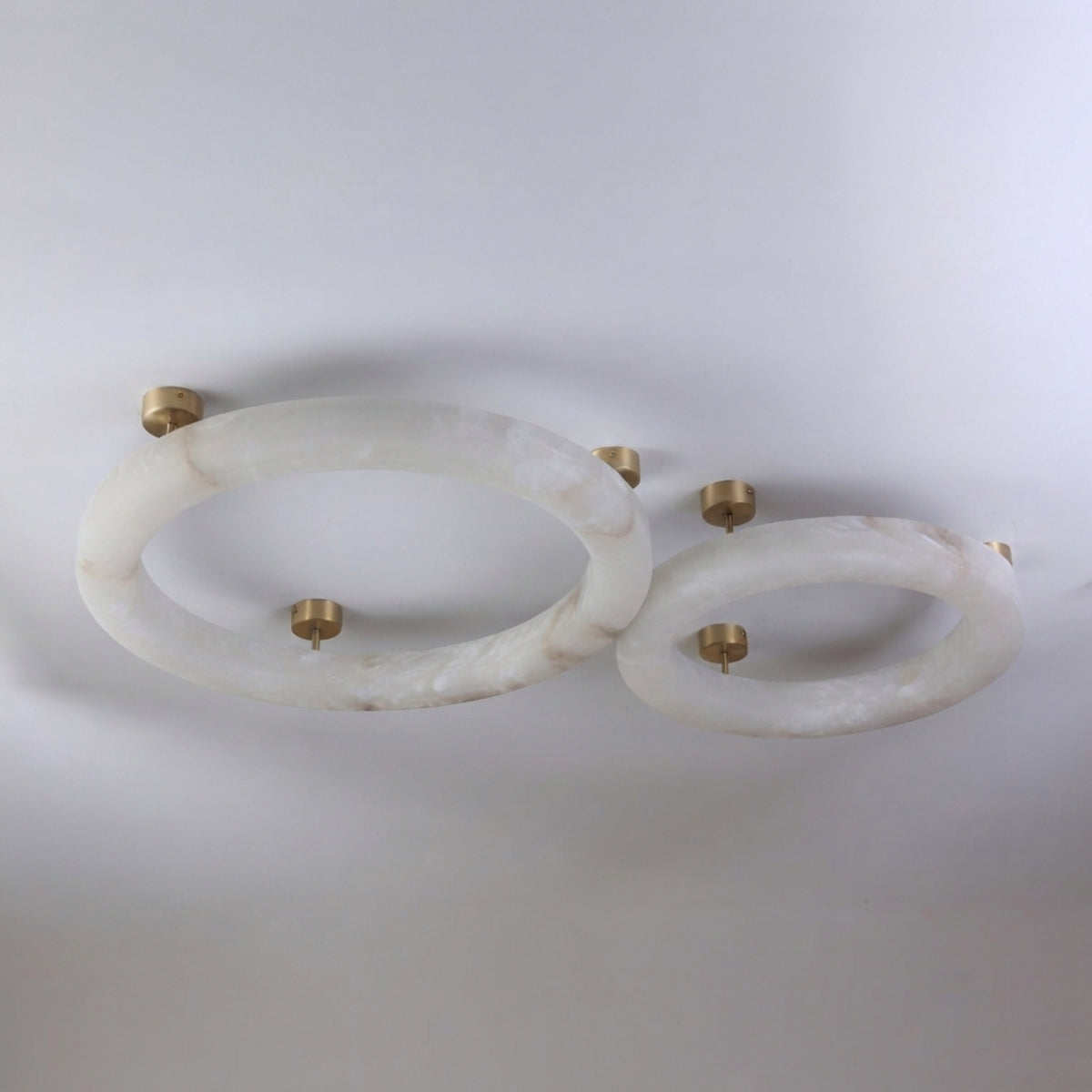 Orbis Extra Large LED Alabaster Semi-Flush Ceiling Light in soft white, shown as two oval rings with brushed brass ceiling mounts against a plain white background.