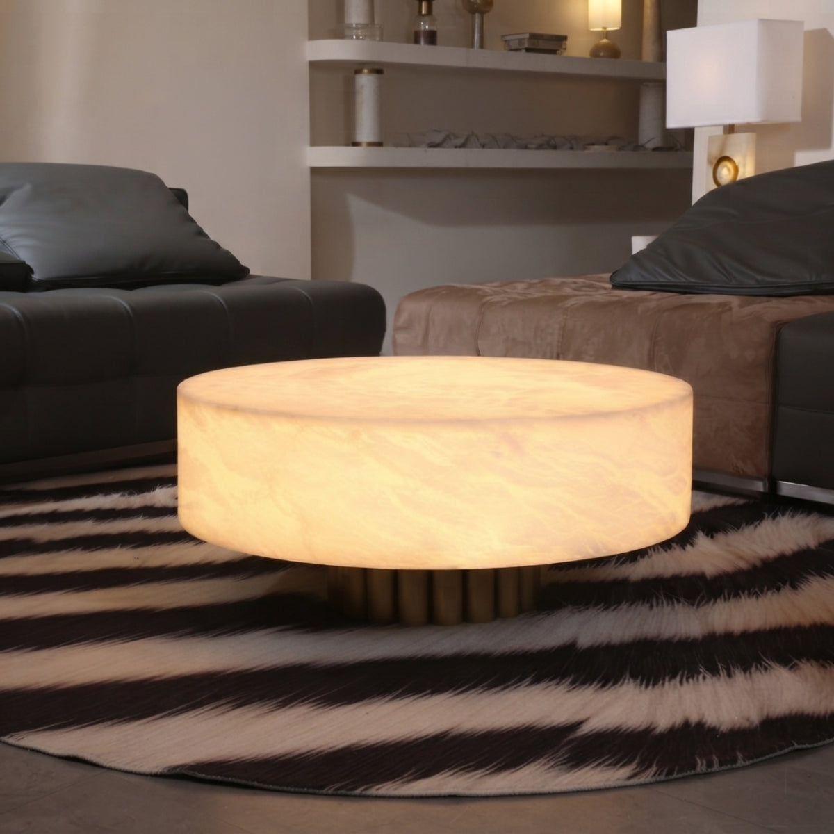 Alurien LED large alabaster coffee table with soft white glowing drum top, shown illuminated on a round zebra-print rug in a living room setting.