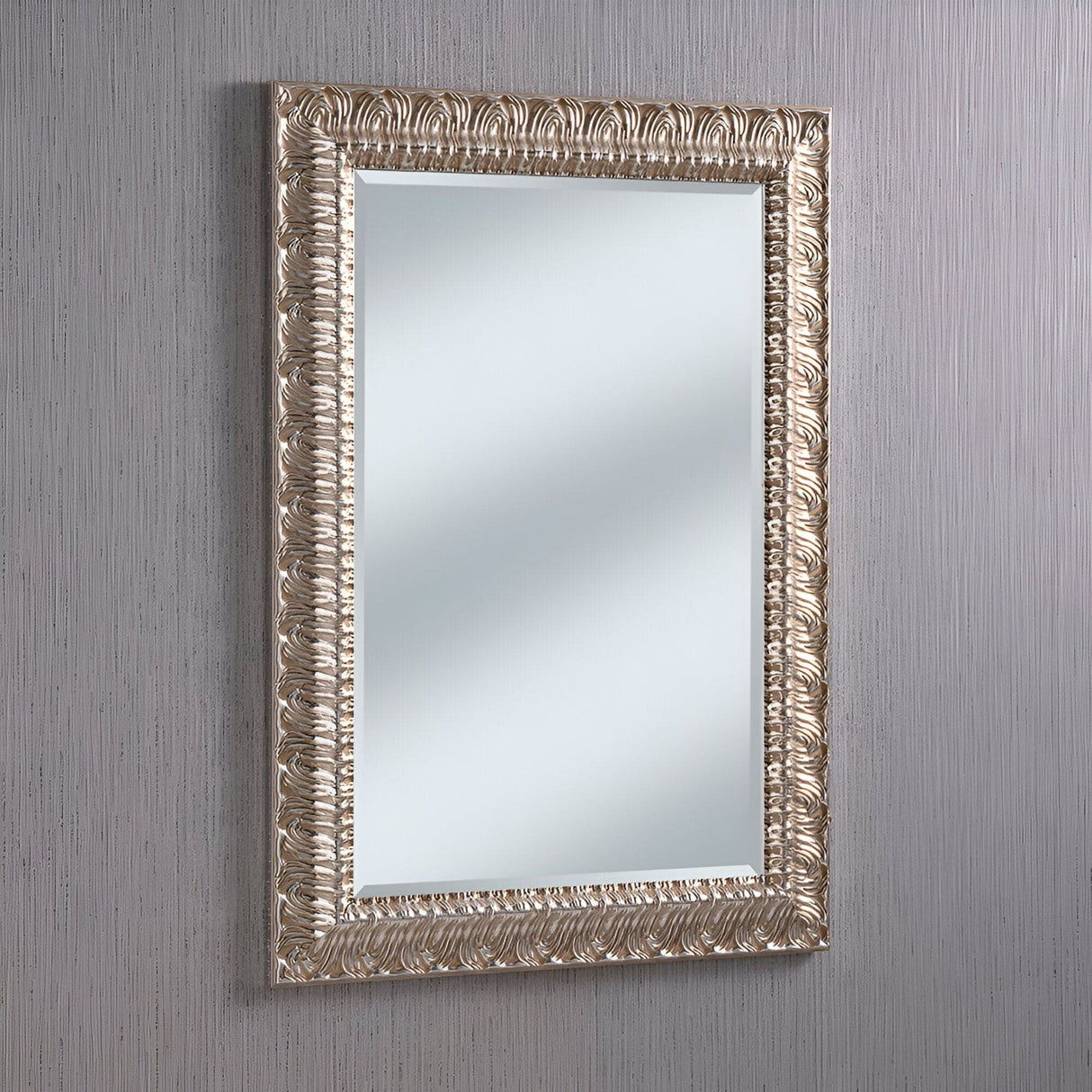 The Crown Rectangle Wall Mirror - Silver features an ornate rectangular design with a stunning silver frame, beautifully displayed against a light gray textured wall. The intricate carvings and modern elements combine timeless elegance with versatile charm.