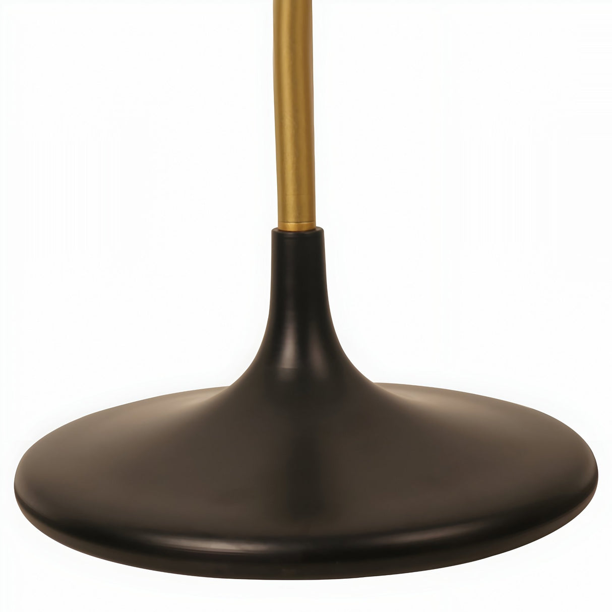A close-up of the round black base and brass pole of the Funk Floor Lamp - Brass highlights its sleek, modern design against a white background.