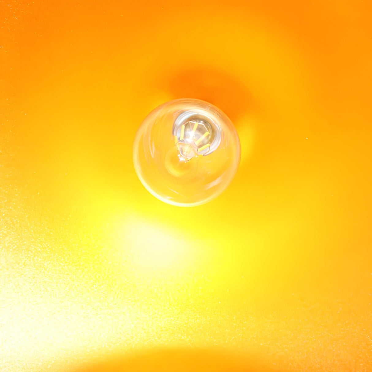 The Funk Stout Small Pendant Light - White glows from above against a vivid orange and yellow backdrop, creating a radiant halo that makes it ideal for modern interiors and minimalist decor.