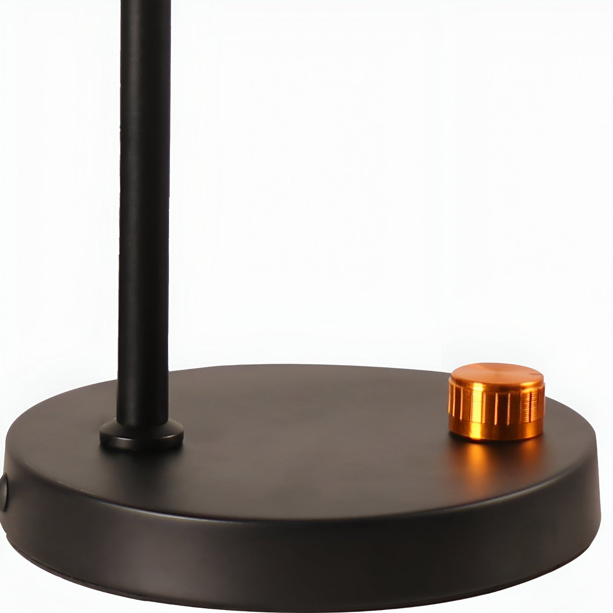 A close-up of the Funk Table Lamp - Black shows its round base, vertical pole, and orange metallic knob, highlighting a minimalist design against a plain white background.