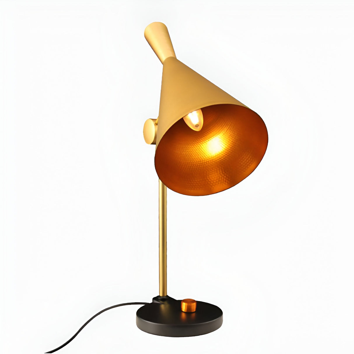 The Funk Table Lamp - Brass features a minimalist design with a cone-shaped shade, cylindrical brass stem, round black base with a gold knob. Plugged in and illuminated, it casts a warm light—perfect for modern spaces.