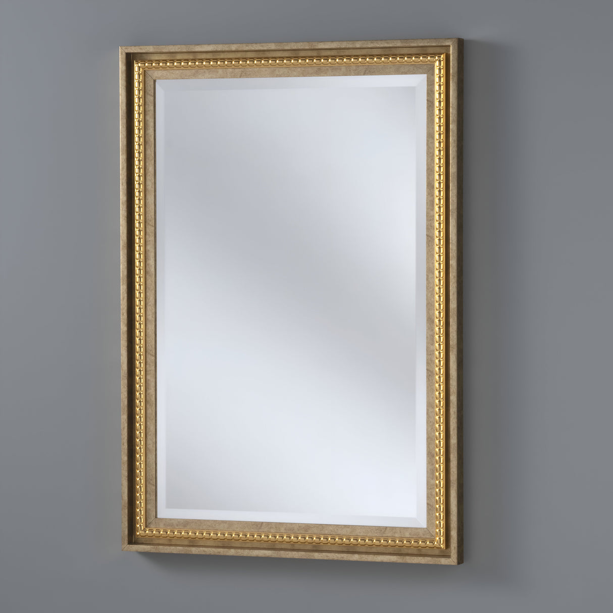 The Chimeris Rectangle Wall Mirror in gold, with its ornate design and decorative beaded pattern, elegantly hangs on a gray wall. Its classic appearance enhances various interior styles.