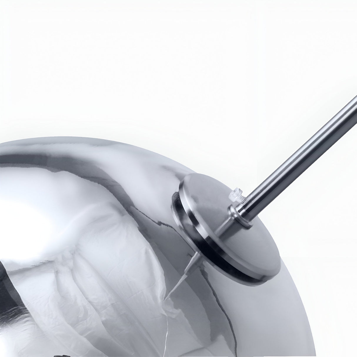 Close-up of the Grand Ball Glass Pendant 25cm - Silver, featuring a shiny metallic sphere with an attached rod and circular plate, reflecting light and its surroundings on a smooth surface against a plain white background.