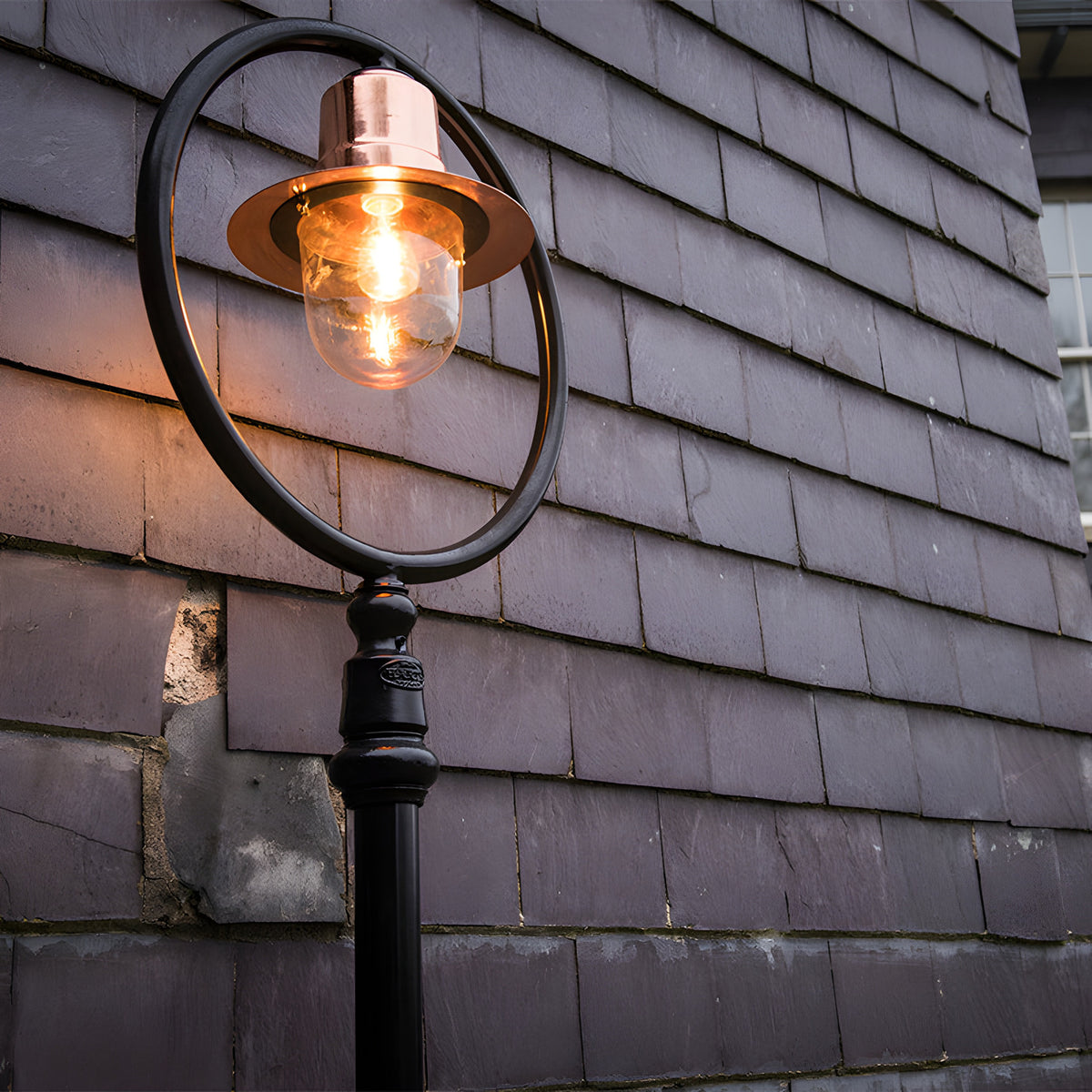 Railway Style Cast Iron Lamp Post, 2.73m, with copper spun shade over a clear glass dome within a black hoop frame, set against a slate-tiled wall.